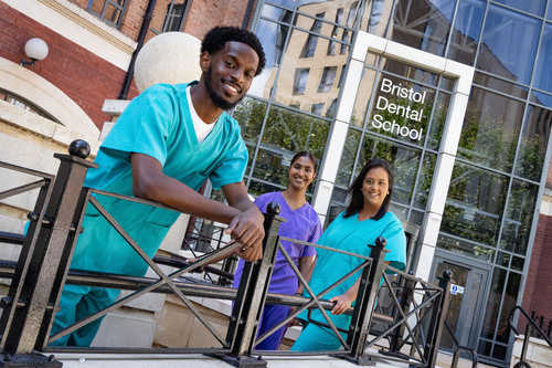 Three dentistry students posing outside of the new Bristol Dental School building.